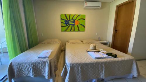 伊波茹卡FLAT MARULHOS的两张床位于带顶帽的房间
