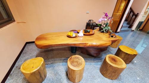 三义三义漫山艺民宿的一张木桌,四周放着一堆木头