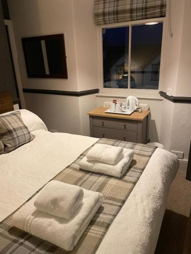 鲍内斯温德米尔皇家橡树旅馆的一间卧室配有带毛巾的床
