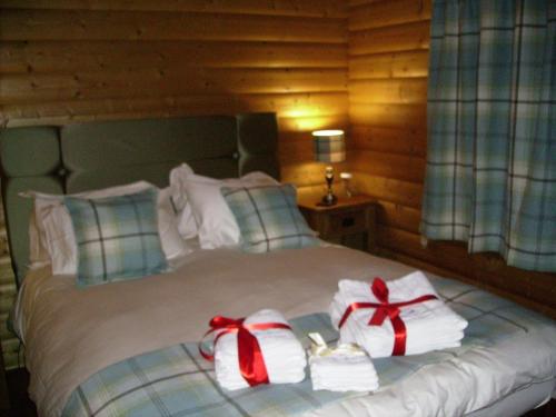 卡莱尔Pheasant Lodge Scottish Borders的床上有两条毛巾和弓