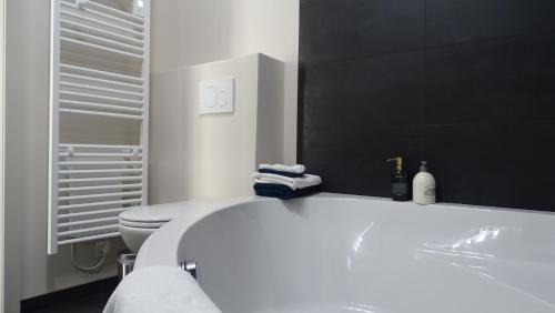 图尔奈Côté Grange的浴室配有白色浴缸和卫生间。