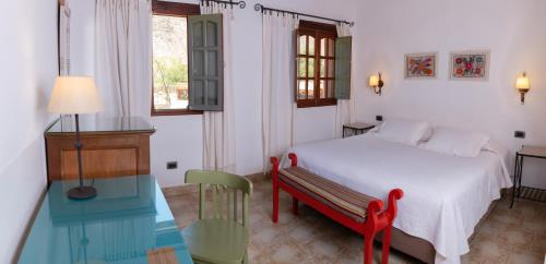 普尔马马尔卡Posta de Purmamarca的一间卧室配有一张床、一张桌子和一个窗户。