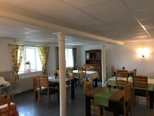 瓦根Hunnebergs Gård Hostel & Camping的一间带桌椅的用餐室和一间带桌椅的角落间