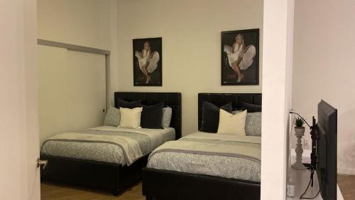 洛杉矶Exceptional Loft FREE Parking and WIFI的卧室配有两张床,墙上挂有两张照片