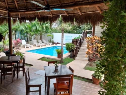 巴卡拉尔Azul 36 Hotel的一个带桌椅的庭院和一个游泳池
