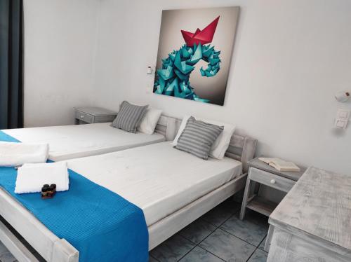 纳乌萨Isalos Paros的一间设有两张床的客房,墙上挂着一幅画