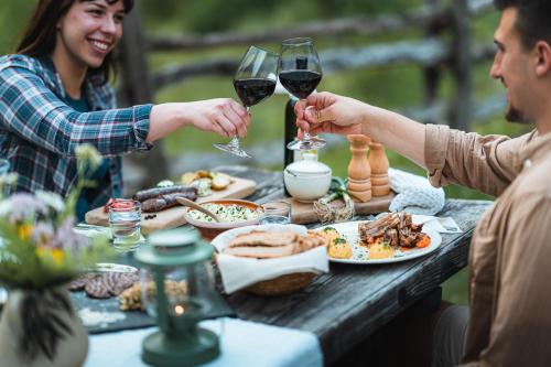 特伦塔Organic Tourist Farm Pri Plajerju的两人在餐桌上喝葡萄酒,一起吃饭