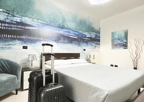 奇维塔韦基亚Skyline的酒店客房,带一张床和行李箱