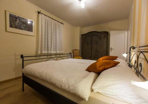 PalagnedraAntica Osteria Ghiridone的一间卧室配有带白色床单和橙色枕头的床。