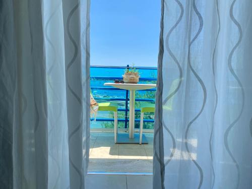 切萨雷奥港FronteMare Rooms的从桌子的窗户欣赏海景