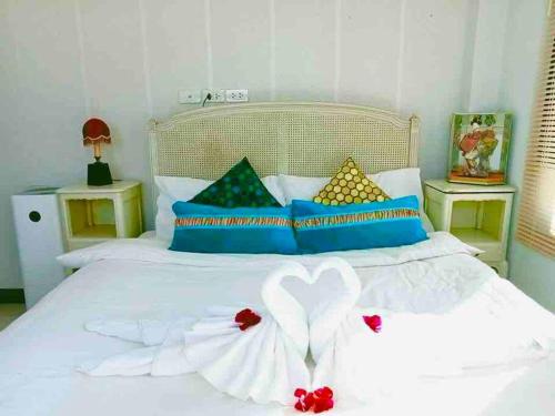 清莱Colorful Pool Villa, Chiang Rai, Thailand的卧室配有白色床和心灵装饰