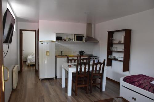 马德普拉塔La MagnoliaII的厨房配有白色冰箱、桌子和椅子