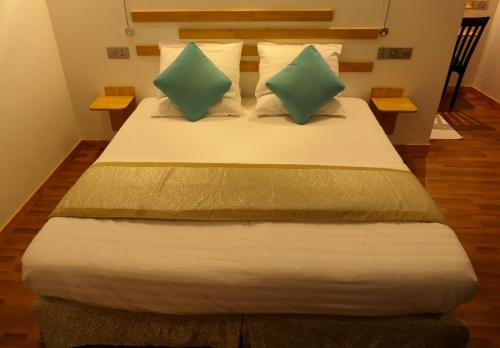 FeridhooAYIRA Maldives的一间卧室配有一张带两个绿色枕头的床
