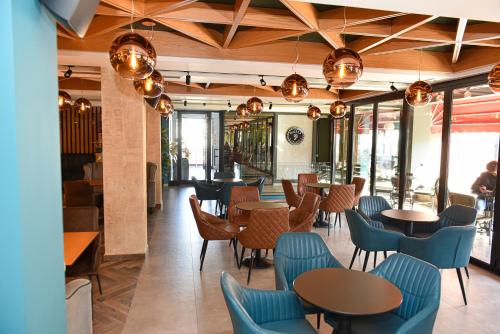 GramshHotel Tomorri的餐厅设有木制天花板和蓝色的桌椅