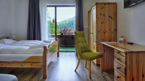 拉姆绍达赫斯坦斯蒂埃勒酒店的一间卧室配有一张床、一张书桌和一个窗户。