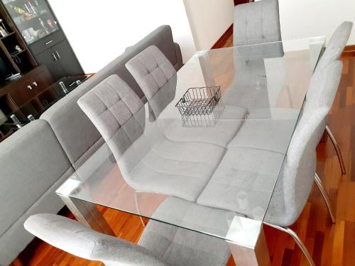特鲁希略Hermoso Apartamento en el Centro de Trujillo的一张玻璃桌,上面有两把椅子和一辆购物车