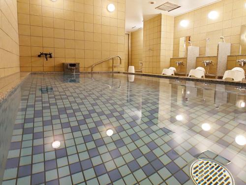沼津Kuretake Inn Premium Numazu Kitaguchi Ekimae的浴室设有游泳池、卫生间和镜子