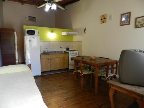 波特雷罗德洛斯弗内斯Complejo Los Molles的厨房配有桌子和白色冰箱。