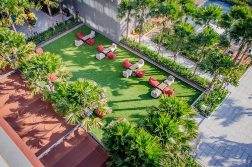 呵叻Aisana Hotel Korat的享有草坪上方的椅子和棕榈树美景