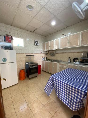 阿哈达روز الهدا的厨房配有桌子和白色冰箱。