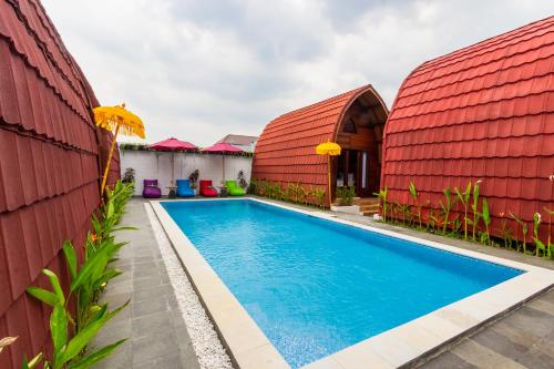 SeturanOmah Lumbung Yogyakarta的一座红色屋顶房屋前的游泳池