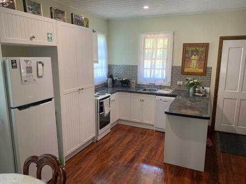 沃尔哈拉Sancreed Cottage的铺有木地板的厨房配有白色家电