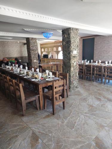 乌树故里Hotel Tekla的用餐室配有大型木桌和椅子