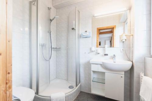 巴特维塞贝尔维尤酒店 的带淋浴和盥洗盆的白色浴室