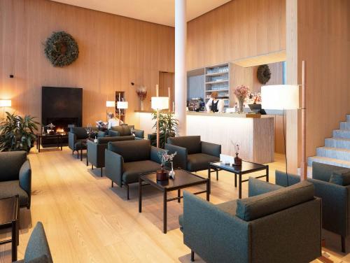 卡斯特尔罗托Schgaguler Hotel的大堂配有沙发、椅子和壁炉