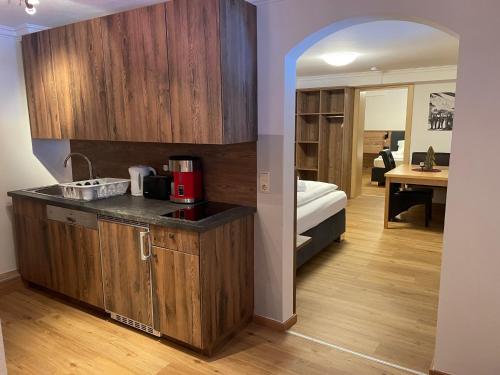 萨尔巴赫Haus Willibald的一个带木制橱柜的厨房和一张位于客房内的床