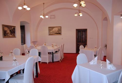 Topoľčianky托佩尔森基扎莫克酒店的宴会厅配有白色的桌椅