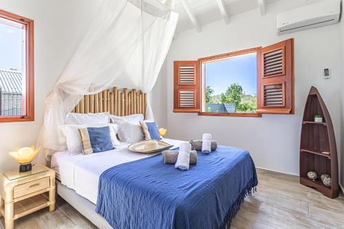 CadetBungalow Sonia的一间卧室配有一张带蓝色床单和窗户的床。