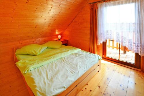 雅罗斯瓦维茨Holiday resort, Jaroslawiec的木制客房的一张床位,设有窗户