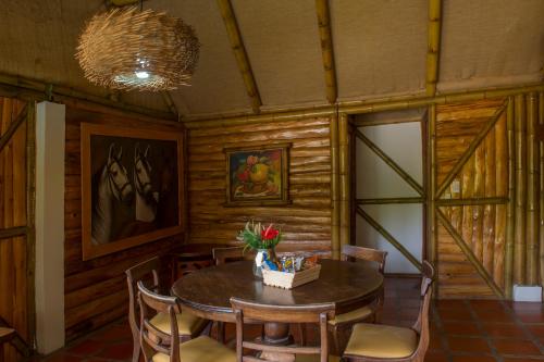 马尼萨莱斯Hacienda Charrascal Coffe Farm的木制用餐室配有桌椅
