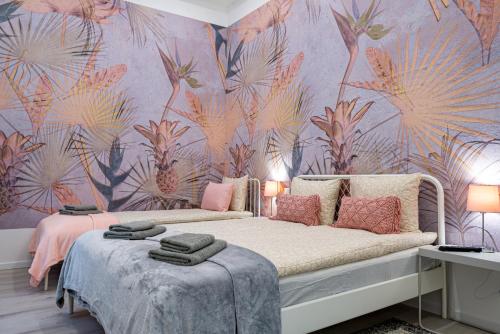 布达佩斯布达佩斯和谐度假公寓的一间卧室配有一张粉红色花壁纸的床