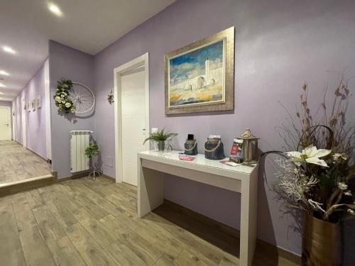 佛罗伦萨Porta alla Croce Guest House的一间设有白色书桌和紫色墙壁的客房