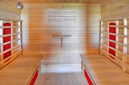 OsiekiHoliday resort, Osieki的小型桑拿浴室设有木墙和长凳