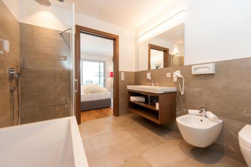 阿皮亚诺苏拉斯特拉达Hotel Lambrechtshof的浴室配有盥洗盆、卫生间和浴缸。