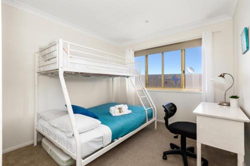 金斯克里福Hungerford Beach Apartment by Kingscliff Accommodation的一间卧室配有双层床和书桌