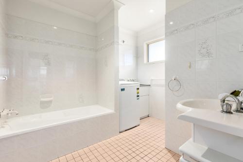 金斯克里福Hungerford Beach Apartment by Kingscliff Accommodation的白色的浴室设有浴缸和水槽。