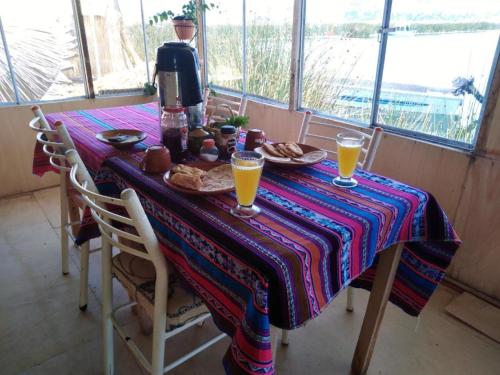 普诺Uros Suyawi Titicaca Lodge的一张桌子,上面放有橙汁,上面放有咖啡壶