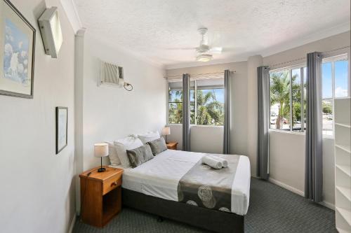 凯恩斯凯恩斯边城假日公寓的一间卧室设有一张床和一个大窗户