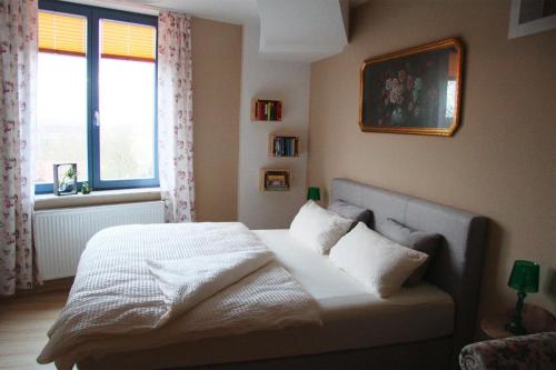 居斯特罗Holiday flat im Wasserturm Güstrow - DMS01100b-P的一间卧室配有一张带白色床单的床和一扇窗户。