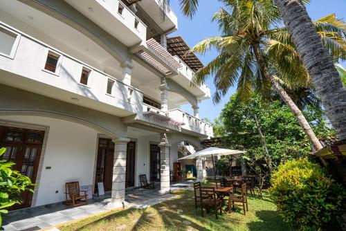 米迪加马东Plantation Surf Inn & Restaurant的享有带桌子和棕榈树的外部景色