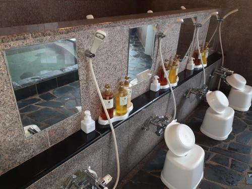 白马村白马炊烟酒店的浴室设有淋浴,备有许多瓶子