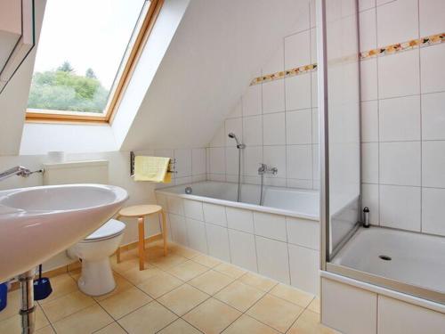 米罗Holiday resort in the Müritz National Park, Mirow的浴室配有盥洗池、卫生间和浴缸。