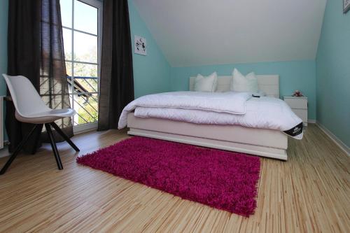 LenzCottage in Lenz的一间卧室配有一张带粉红色地毯和椅子的床