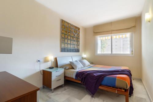 阿罗约德拉迷雅Benalmadena with seasonal pool & parking near the beach的一间卧室配有一张床、一张书桌和一个窗户。