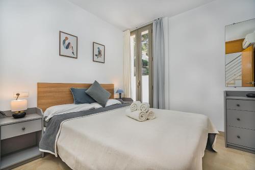 卡拉圣维森特莫林斯4号度假屋的一间卧室配有一张床,上面有两条毛巾
