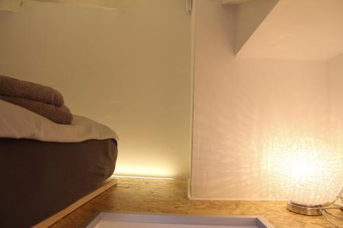 斯图加特gemütliches tiny apartment - nur 10min vom Zentrum的一间房间,墙上有一张床和一盏灯